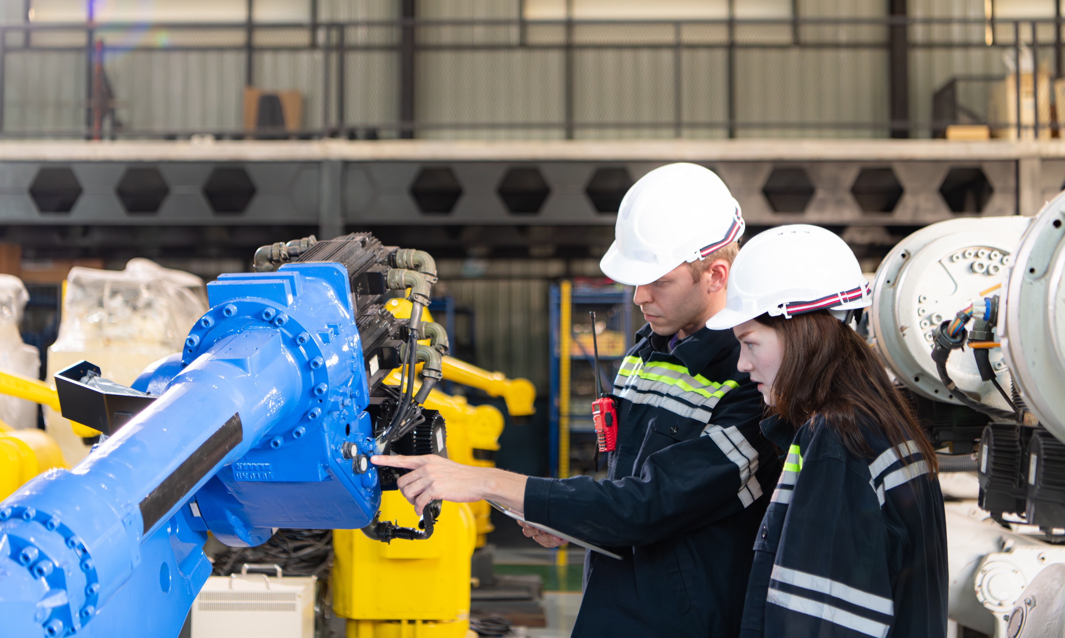 Both of engineers working together in a robotic arm factory, Robotic arm industry and engineering concept.